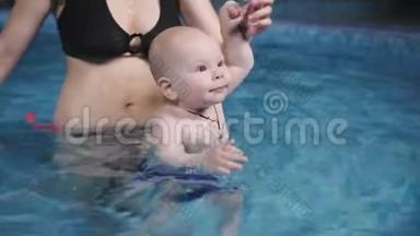 这个小婴儿和他妈妈一起在游泳池里游泳。